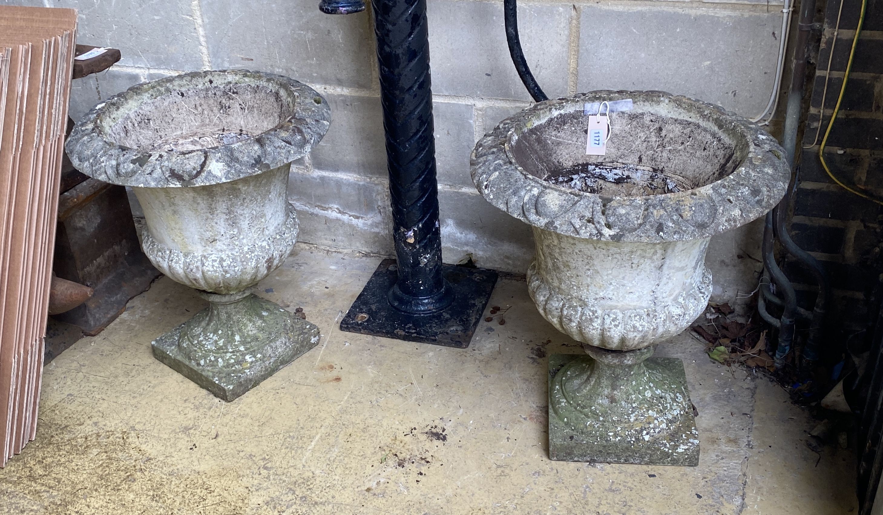 A pair of circular reconstituted stone campana garden urns on bases, diameter 50cm, height 60cm